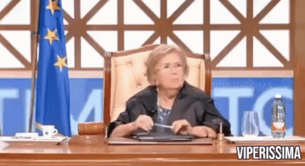 a woman is sitting at a desk in front of a flag with the word viperissima on the bottom