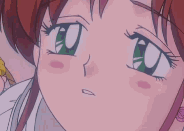 a close up of a girl 's face with green eyes and red hair