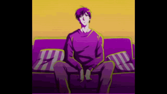 a man in a purple shirt is sitting on a couch .