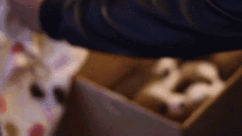 a blurred image of a person opening a cardboard box with a number 25 in it