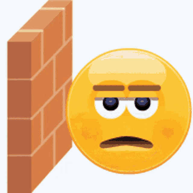 a yellow smiley face with a brick wall behind it