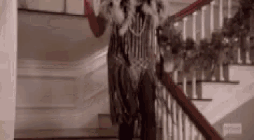 a person in a costume is walking down a set of stairs in a house .