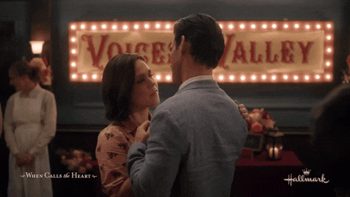 a man and woman dancing in front of a sign that says voice alley