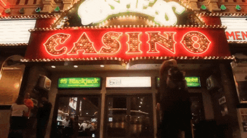 a man stands in front of a casino that has a blackjack machine