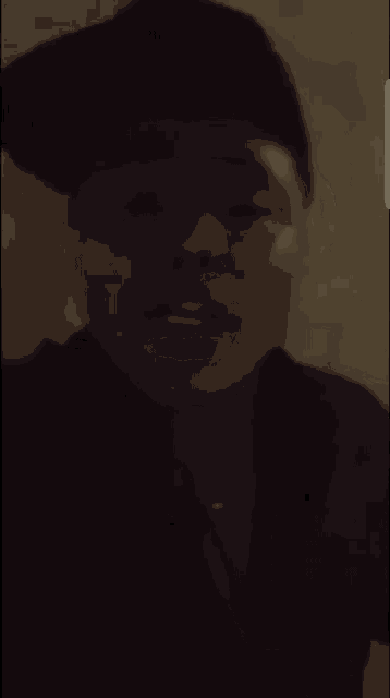 a close up of a person 's face with a black hat on