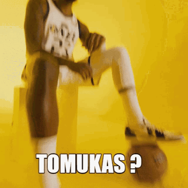 a blurred image of a basketball player with the words " tomukas " written below him
