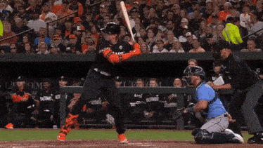 a baseball player swings his bat at a ball while wearing a jersey that says baltimore