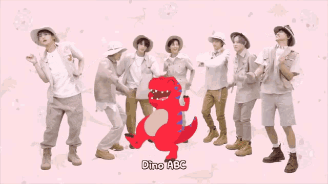 a group of people are dancing in front of a red dinosaur that says dino abc
