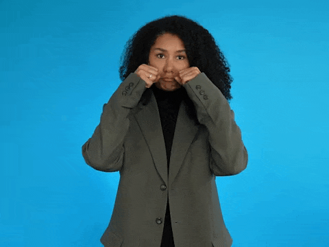 a woman in a suit is making a funny face