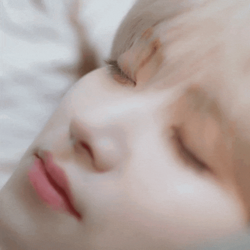 a close up of a person 's face with their eyes closed .