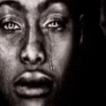 a black and white photo of a man 's face with a tear running down his eye .