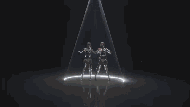 two women are dancing in front of a spotlight