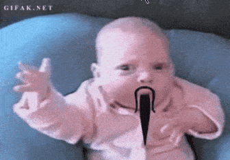 a baby with a mustache is sitting on a blue cushion .