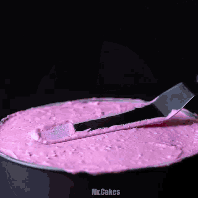 a bowl of pink frosting with the words mr.cakes below