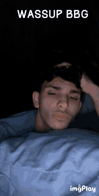 a young man is laying in bed with the words wassup bbc behind him