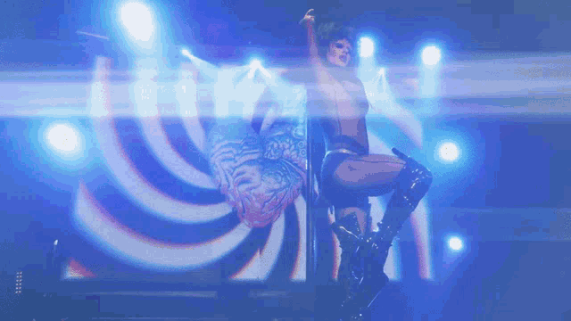 a woman is standing on a pole in front of a swirl of lights