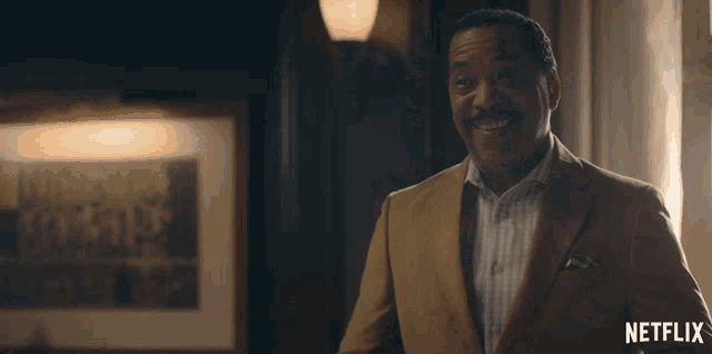 a man in a suit is standing in front of a netflix logo
