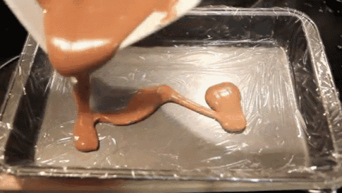 a brown liquid is being poured into a pan