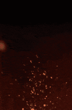 a white circle with a black center is surrounded by sparks and smoke