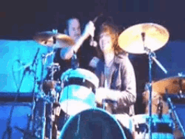 a man playing drums on a stage with a microphone
