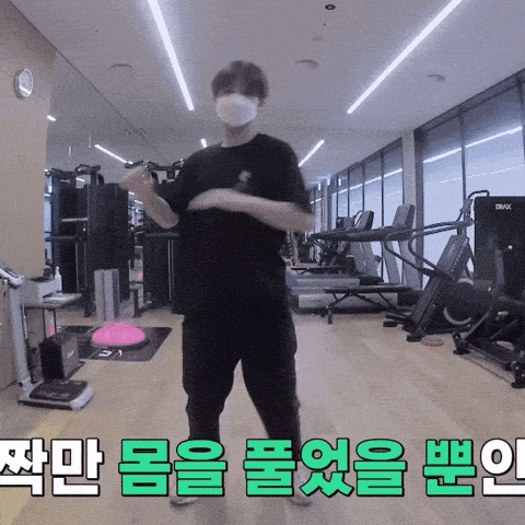 a man wearing a mask is dancing in a gym with korean writing on the floor
