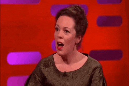 a woman is making a funny face while sitting on a red and purple background .