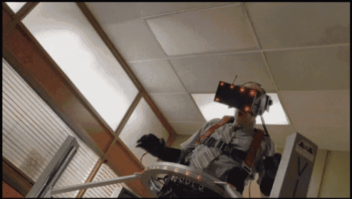 a man wearing a virtual reality headset is standing in front of a box with the letter v on it