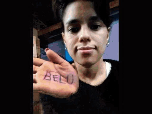 a woman holds her hand up with paula written on it