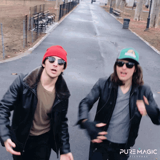 two men wearing sunglasses and a hat with hawaii on it