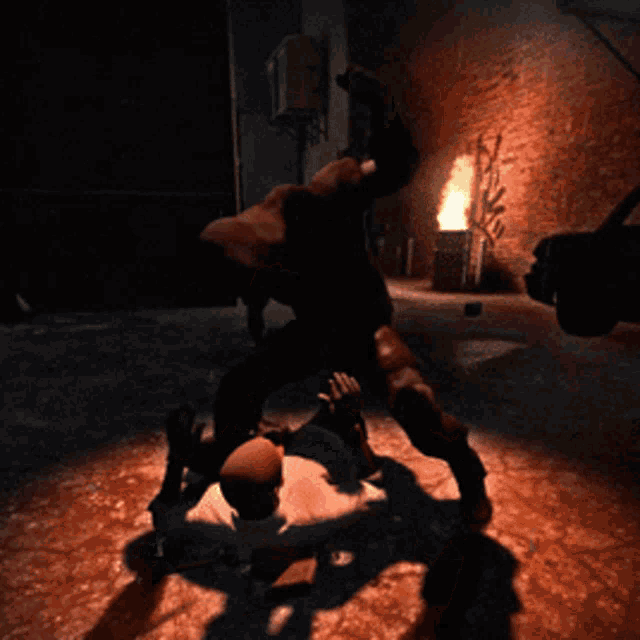 a man is wrestling another man in a dark room with a brick wall in the background