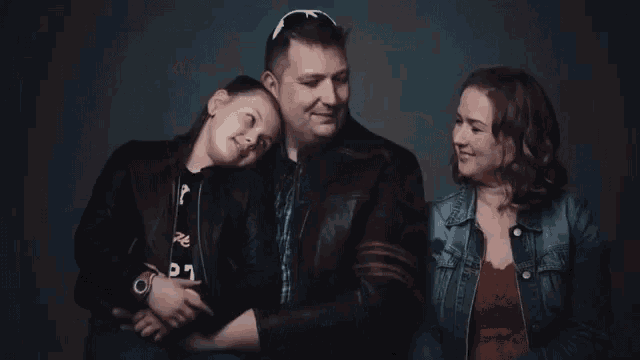 a man and two women are posing for a picture .