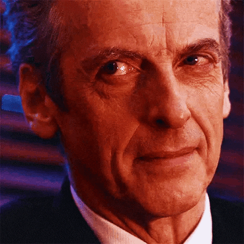 a close up of a man 's face in a suit and tie looking at the camera .