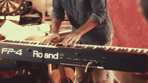 a man is playing a roland fp-4 piano
