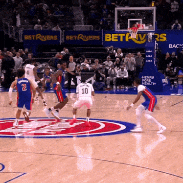 a basketball game is being played in front of a bet rivers sign