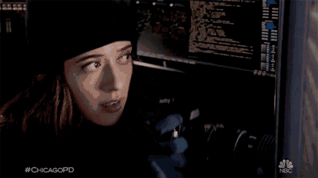 a woman in a black hat stands in front of a computer screen with the hashtag #chicagopd on the bottom