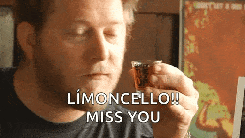 a man is holding a shot glass with the words limoncello miss you written on it