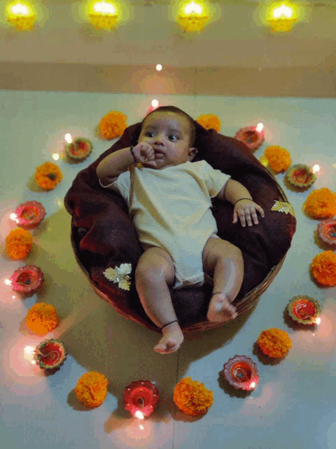 a baby is in a basket surrounded by candles and flowers