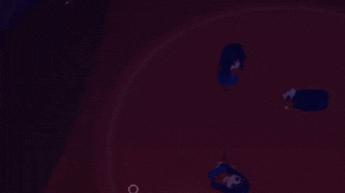 a group of people are standing on top of a red surface in a dark room .