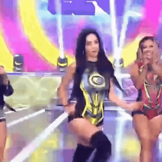 a woman in a superhero costume is dancing on a stage with other women .