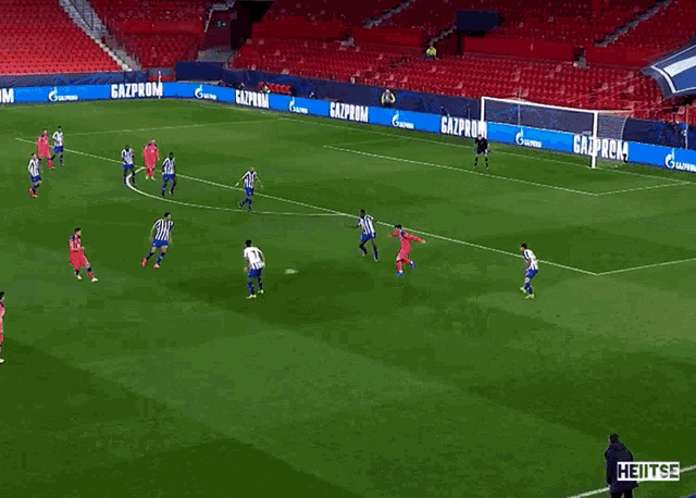 a soccer game is being played on a field with a gazprom banner in the background