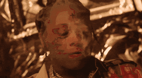 a close up of a man 's face with a cross on it