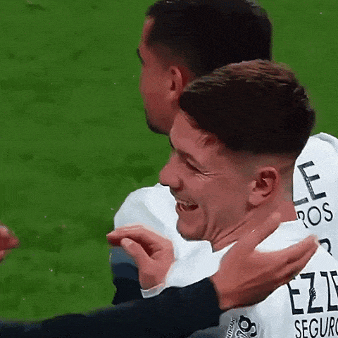 two soccer players are hugging each other and one has a jersey that says ezzi seguro