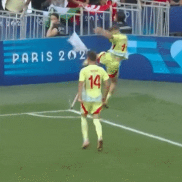 a soccer player in a yellow jersey with the number 14 on it