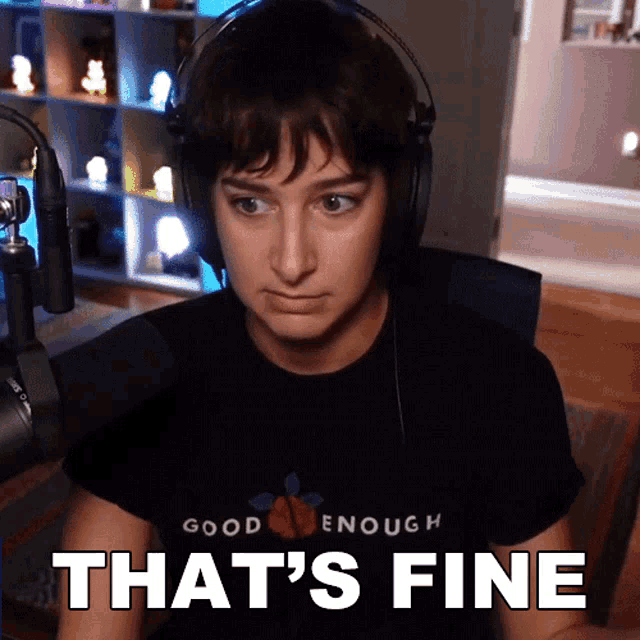 a woman wearing headphones and a shirt that says good enough