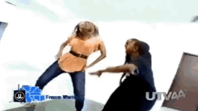 a couple of people dancing in front of a sign that says utvaa