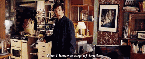 a man is standing in a living room holding a gun and asking if he can have a cup of tea .