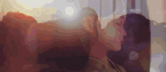 a blurry picture of a man and a woman kissing each other