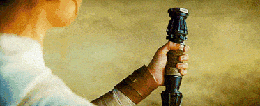 a person is holding a lightsaber in their hand in a close up .
