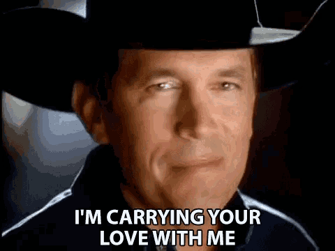 a man wearing a cowboy hat is smiling and says `` i 'm carrying your love with me '' .
