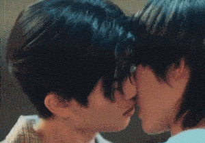 a couple of men are kissing each other in a blurry photo .